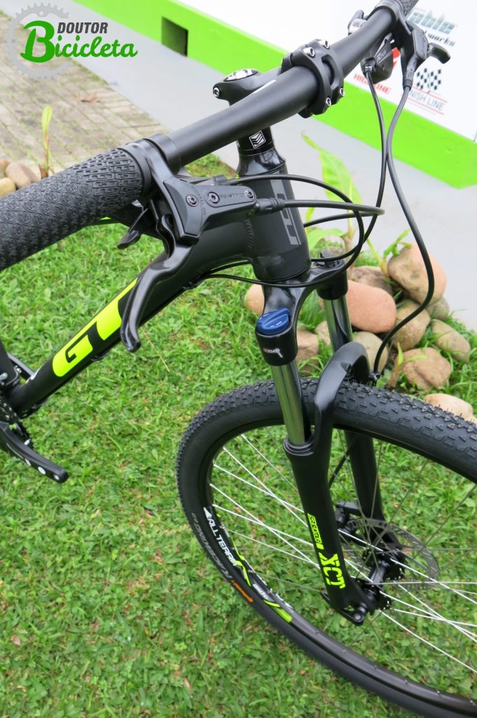 Aros de 29", freio a disco hidráulico, trocadores Shimano Altus e suspensão dianteira SR Suntour XCT com trava no crown.